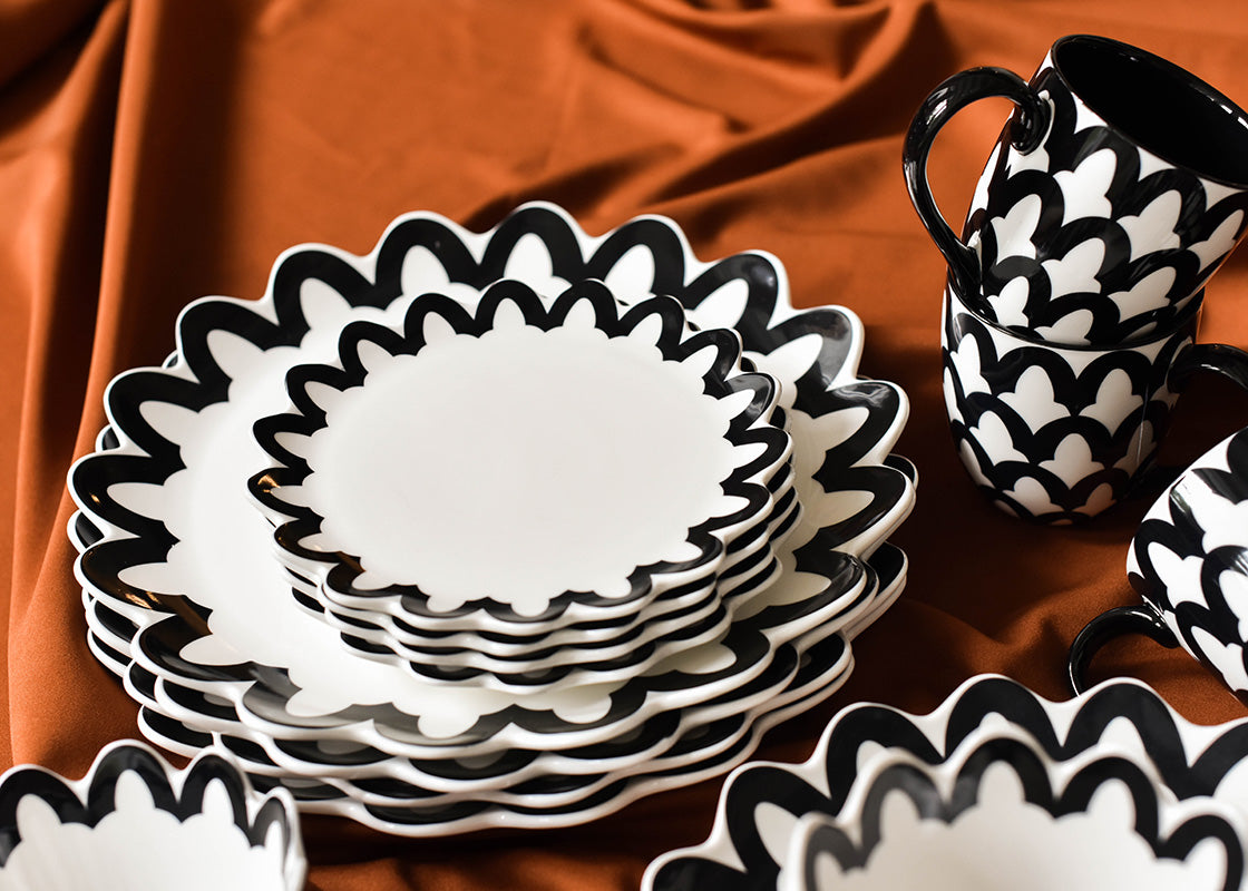 Extreme Cropped Close up of Black Arabesque Trim Scallop Salad Plates set on Stack of Coordinating Dinner Plates