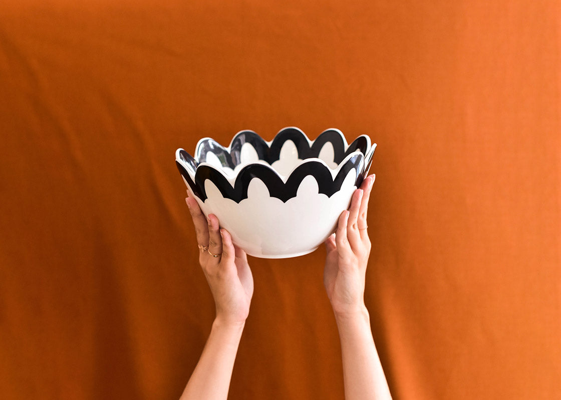 Cropped View of Hands Holding Black Arabesque Scallop 9 Bowl Overhead