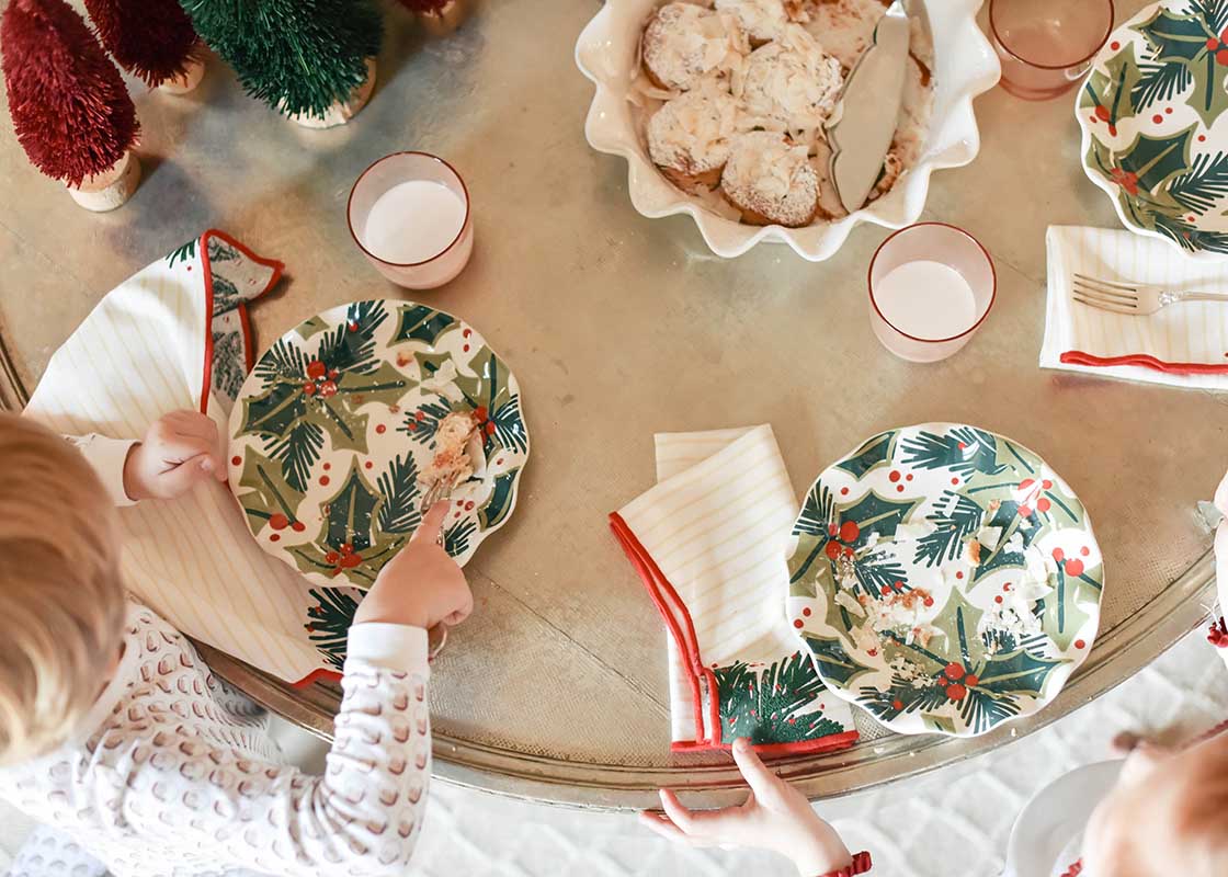 Overhead View of Children Sitting at Table in Front of Place Settings of Holly Ruffle Salad Plate on Christmas Morning