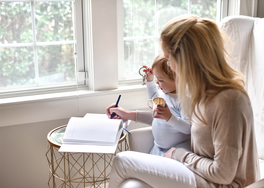 Front View of Woman Sitting with Child at Side Documenting Baby Boy's Every Move in the Blue Celebrate Me Book