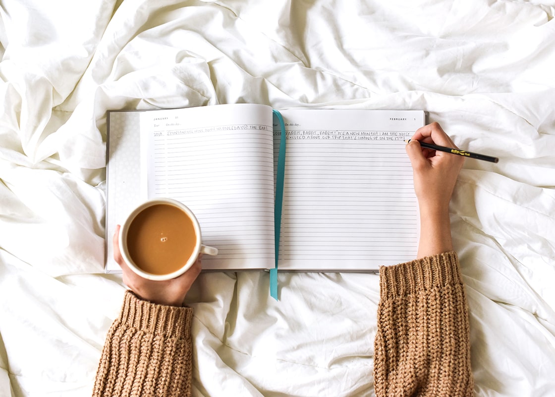 Overhead View of A Person Writing Thoughts of the Day Over Coffee with Celebrate Every Day Book