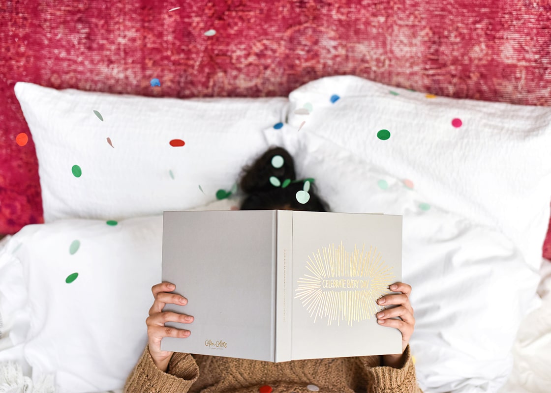 Overhead View of Woman in Bed Holding Celebrate Every Day Book