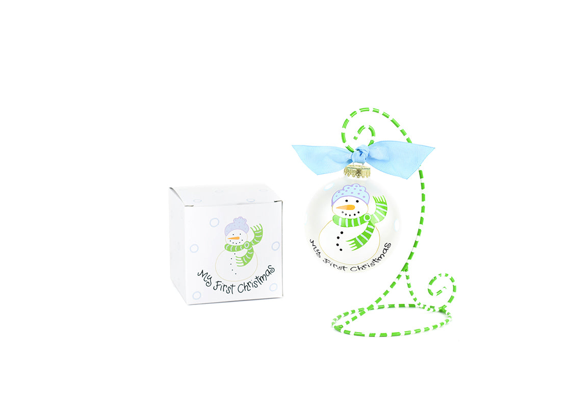 Front View of Blue My First Christmas Snowman Glass Ornament Placed on Green and White Stripe Display Stand and Matching Box