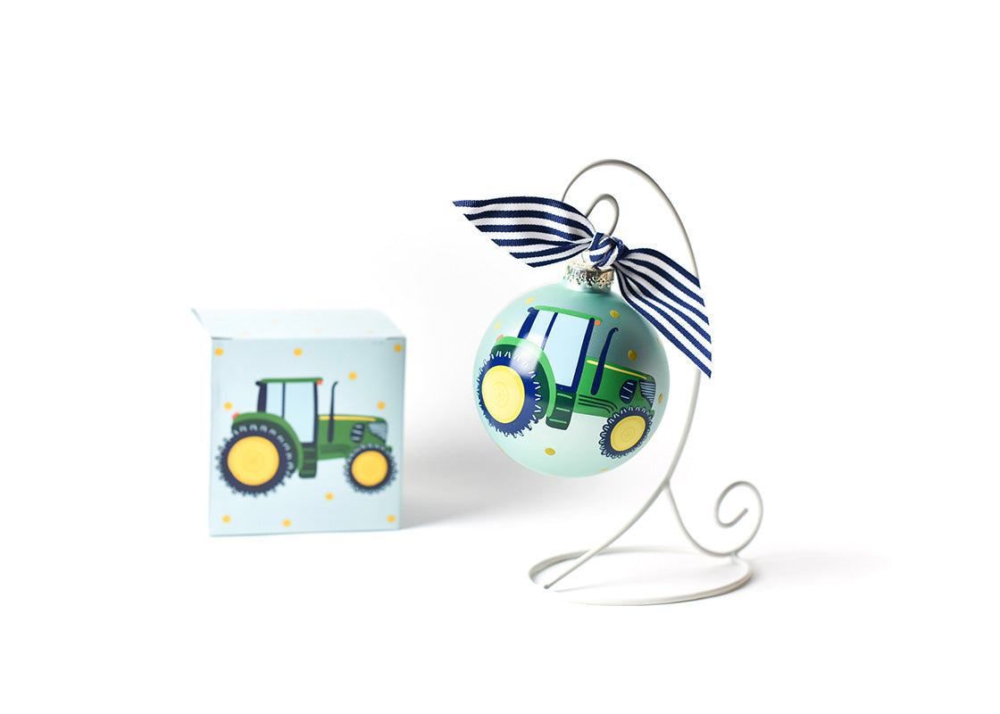 Front View of On the Farm Tractor Glass Ornament Placed on White Display Stand with Matching Box