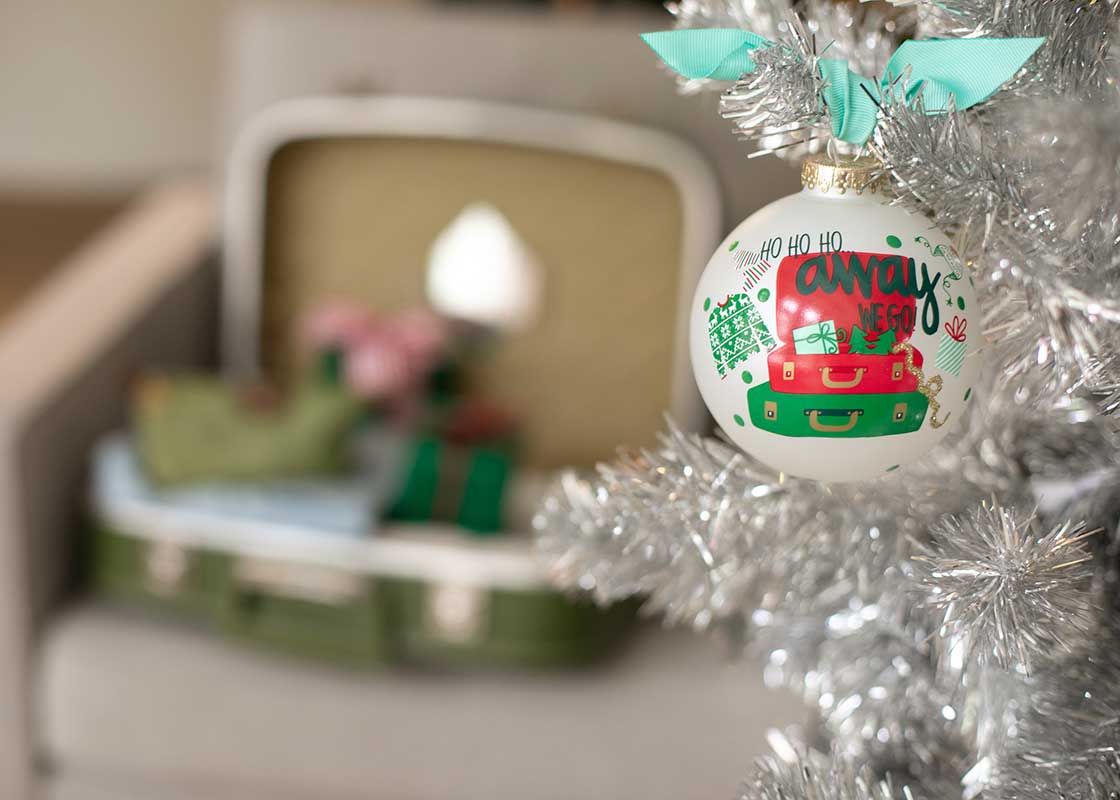 Front View of Glass Ornament Away We Go Design on Silver Tinsel Tree