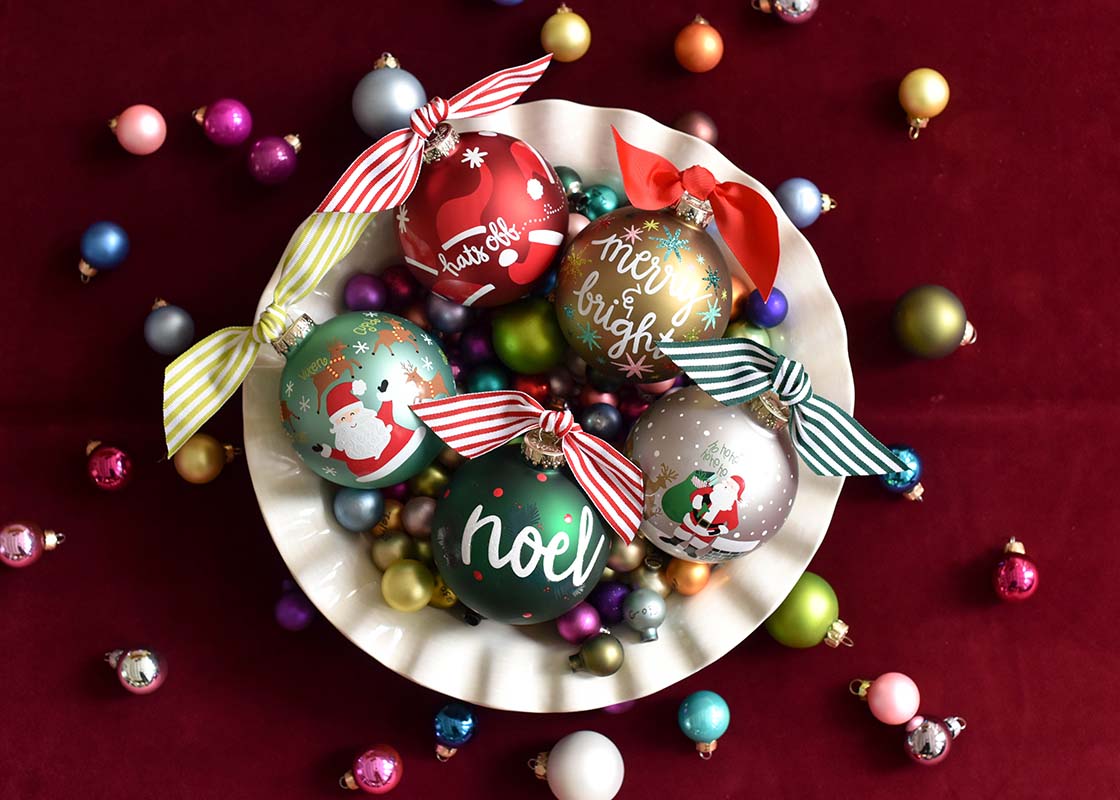 Overhead View of Signature White Ruffle Bowl full of Christmas Ornaments Including Balsam Noel Glass Ornament