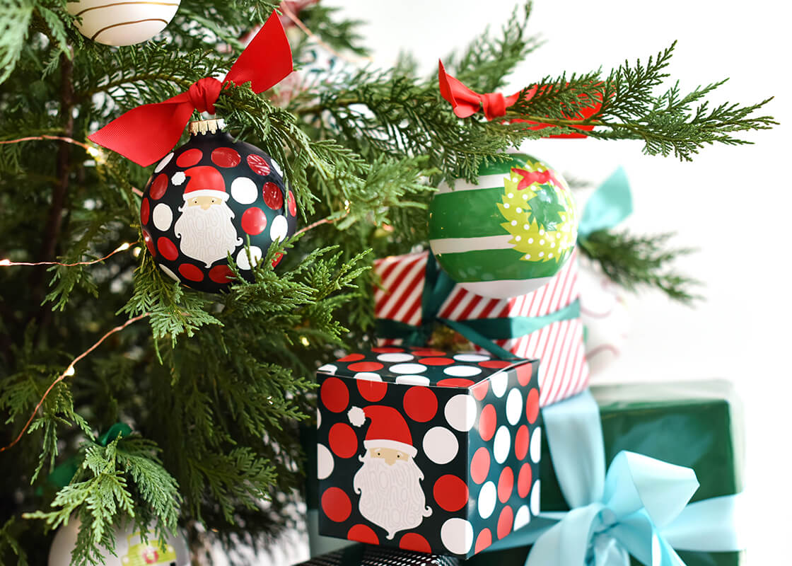 Front View of Ho Ho Santa Glass Ornament Displayed on a Christmas Tree with Matching Gift Box
