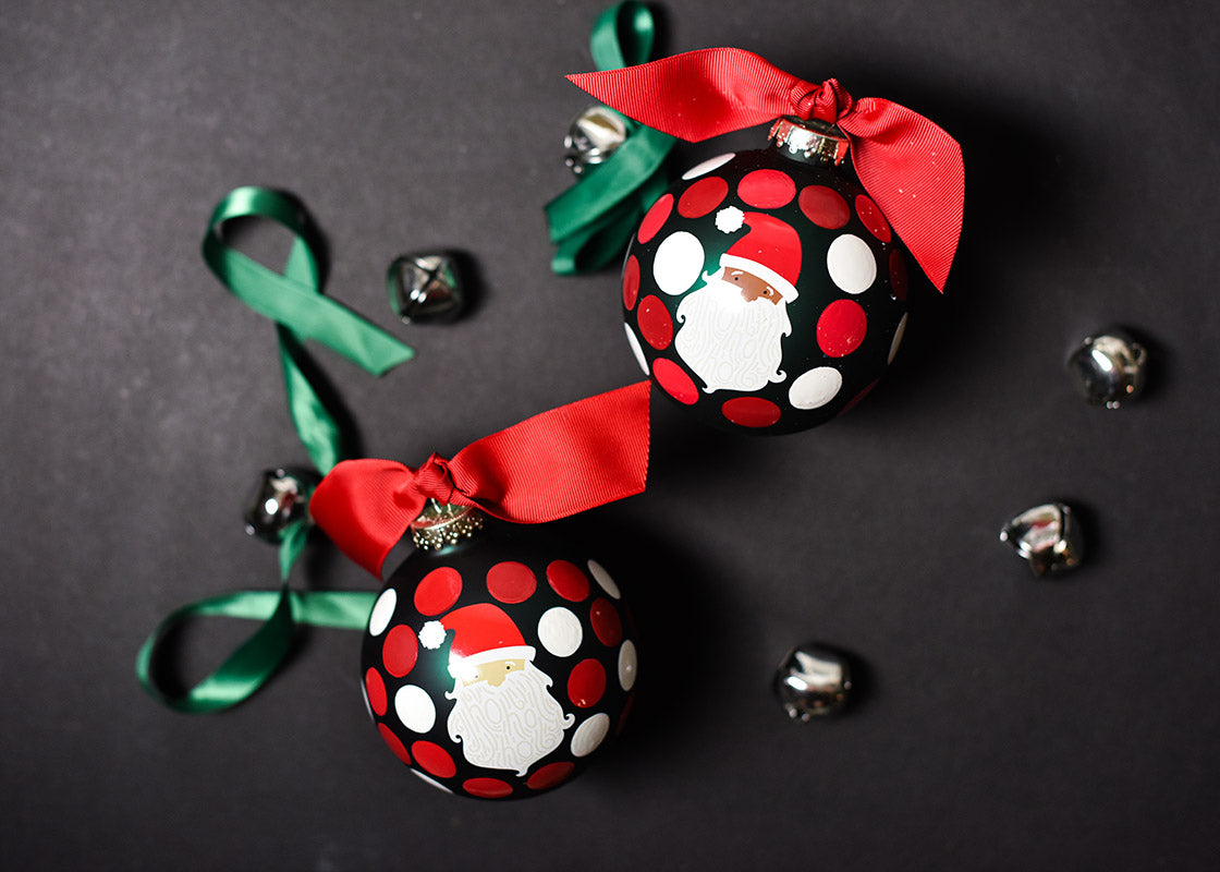Overhead View of Brown and Fair Skin Santa Ho Ho Ho Christmas Ornaments on Black Background