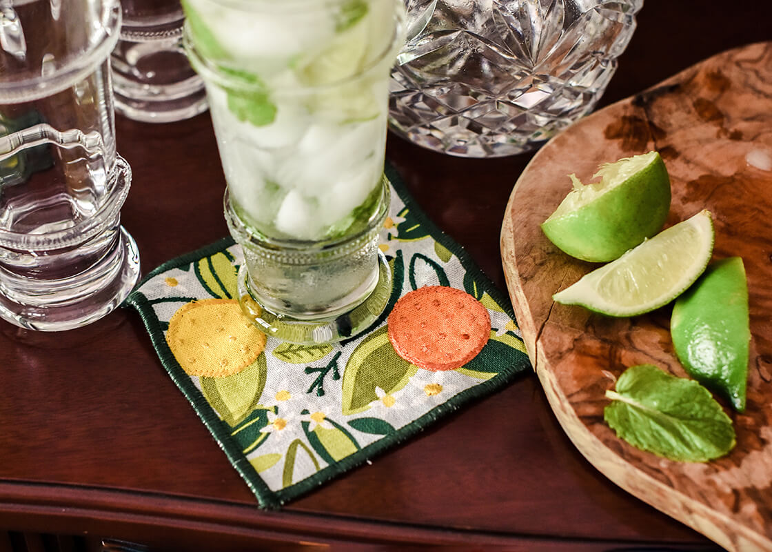 Front View of Cocktail Napkin with Citrus Design Showcasing Green Embroidered Detailed Edge