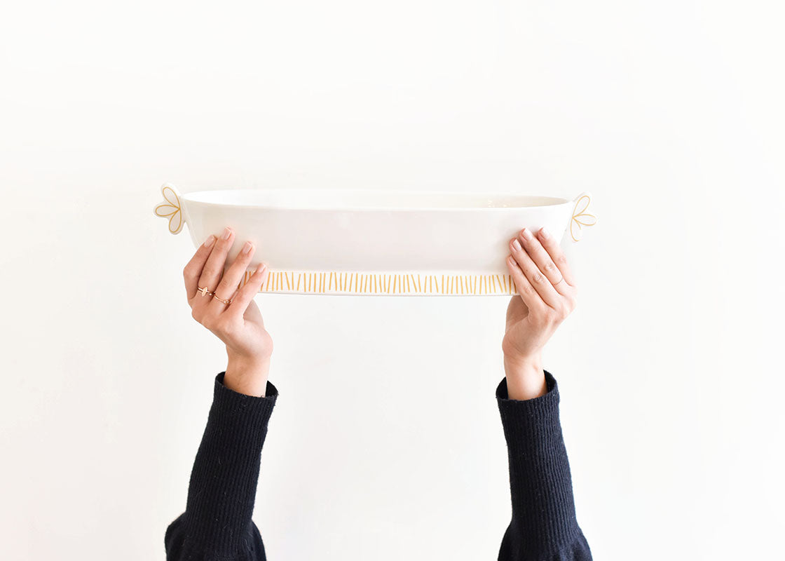 Front View of Hands Holding Deco Gold Scallop Handled Oval Bowl Overhead