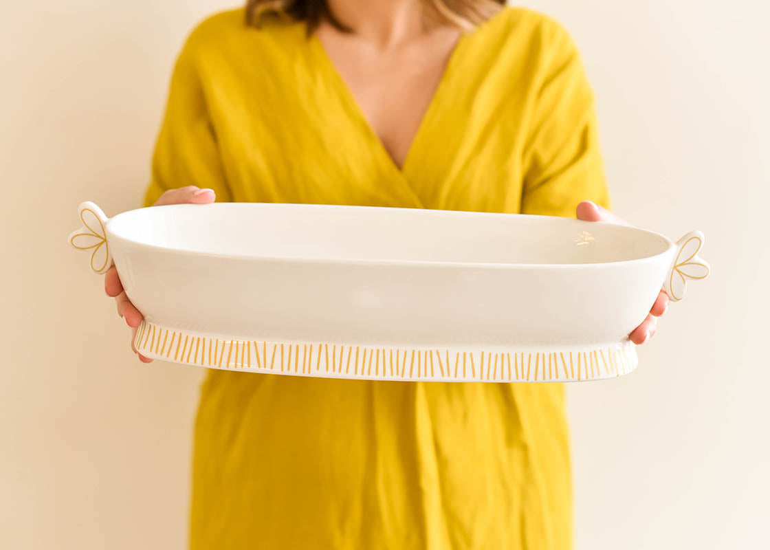 Front View of Woman Holding Deco Gold Scallop Handled Oval Bowl in Front of Her