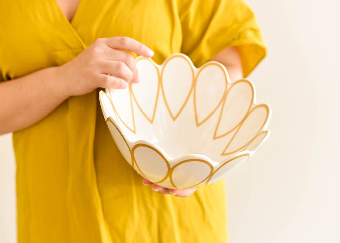 Cropped View of Woman Holding Deco Gold Scallop Serving Bowl Tipped to See Inside Details