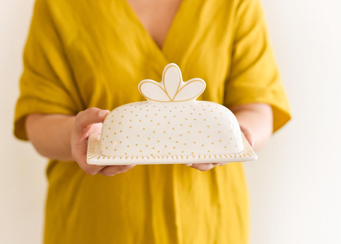 Front View of Woman Holding Deco Gold Scallop Knob Butter Dish