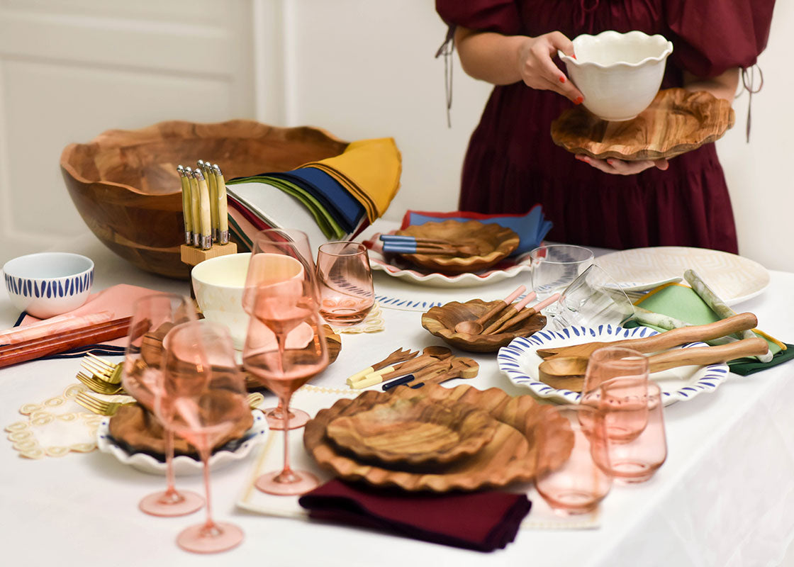 Front View of Woman Holding Bowl Near Tablescape with Coordinating Fundamental Designs Including Large Ruffle Bowl