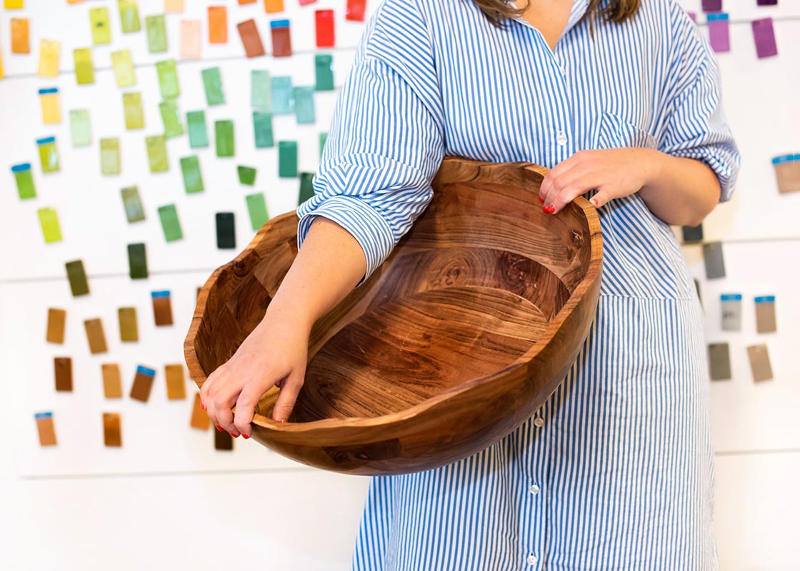 Front View of Woman Carrying Large Ruffle Wood Bowl from Fundamentals Collection
