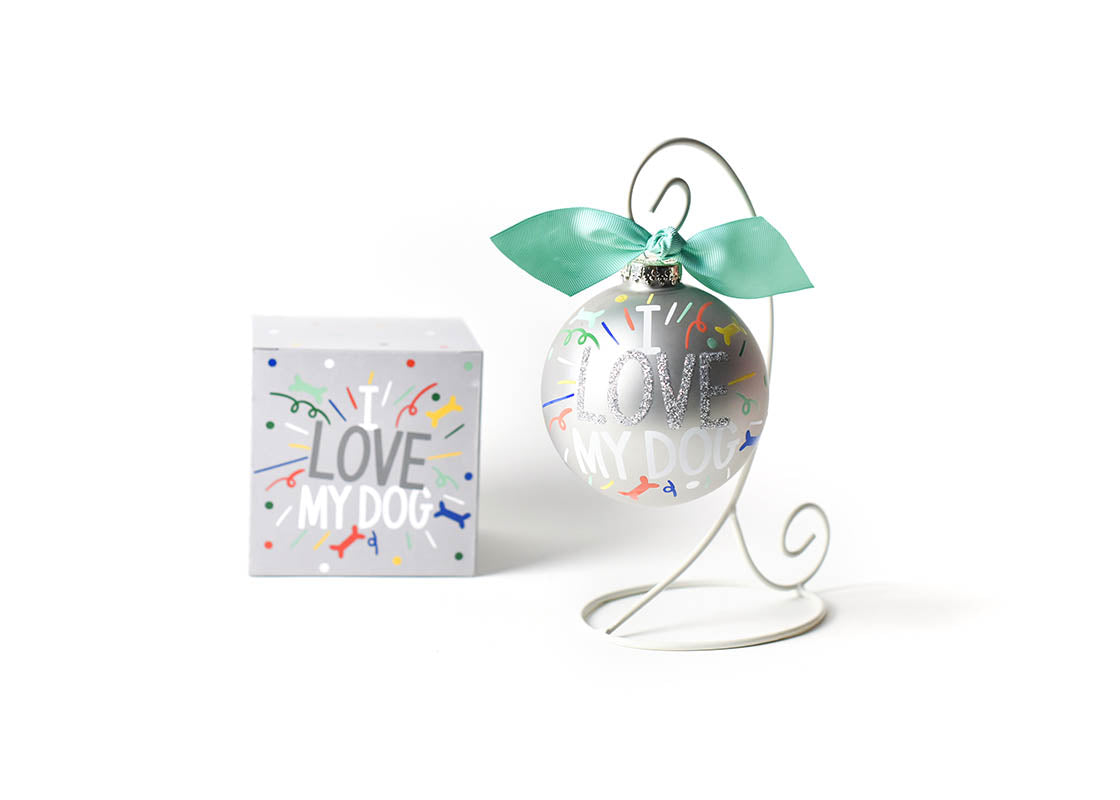 Front View of I Love My Dog Popper Glass Ornament Placed on White Display Stand with Matching Box