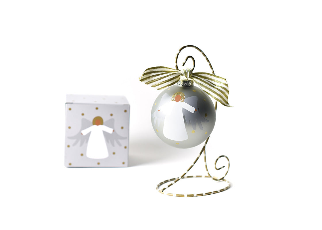 Front View of Brown Skin Forever in Our Hearts Angel Glass Ornament Placed on Gold and White Stripe Display Stand with Matching Box