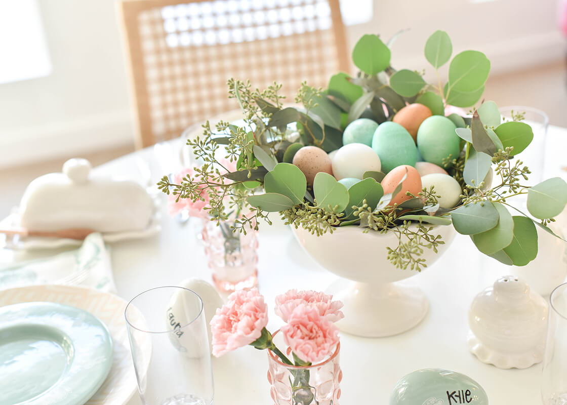 Cropped View of Easter Tablescape Including Signature White Ruffle Trifle Bowl filled with Greenery and Dyed Easter Eggs and Placed as Centerpiece