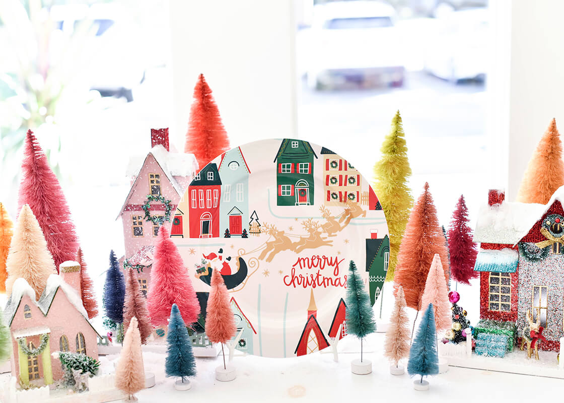 Front View of a Christmas Village Serving Platter on Display on a Table Full of Miniature Colorful Fir Trees