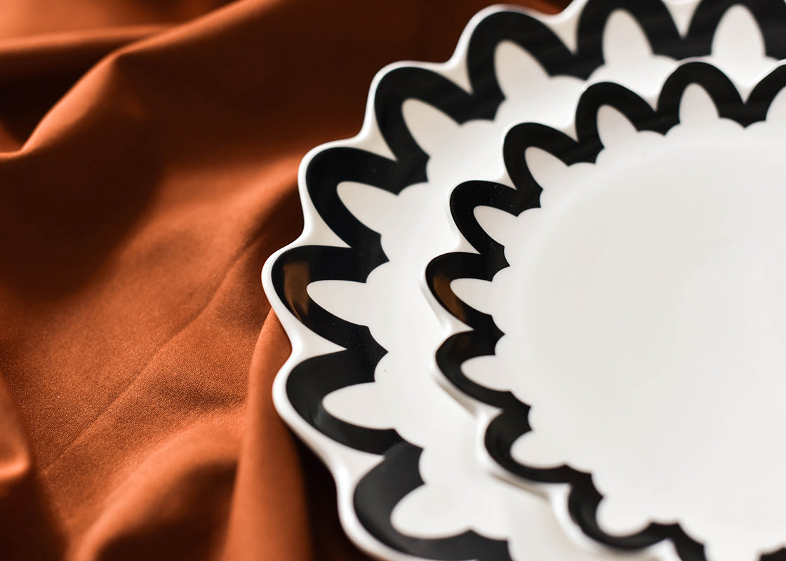 Cropped Close up of Black Arabesque Trim Scallop Dinner Plate and Salad Plate Showcasing Repeating Design