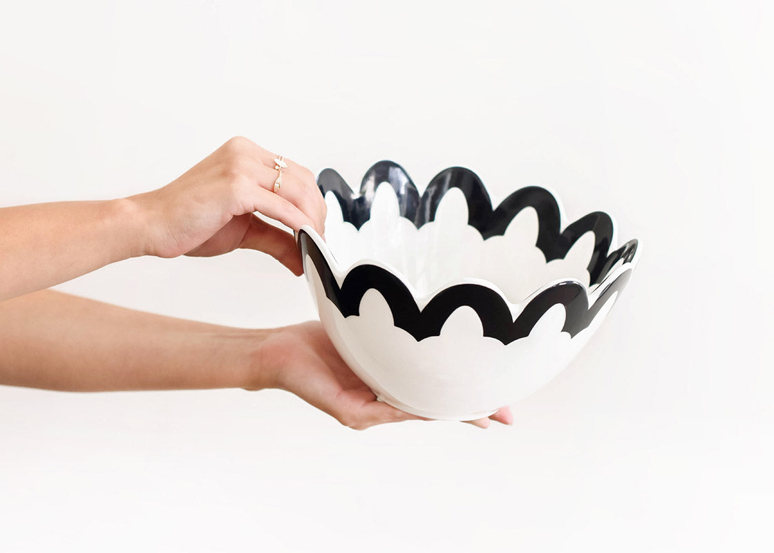 Cropped View of Hands Holding Slightly Tilted Black Arabesque Scallop 9 Bowl from Side