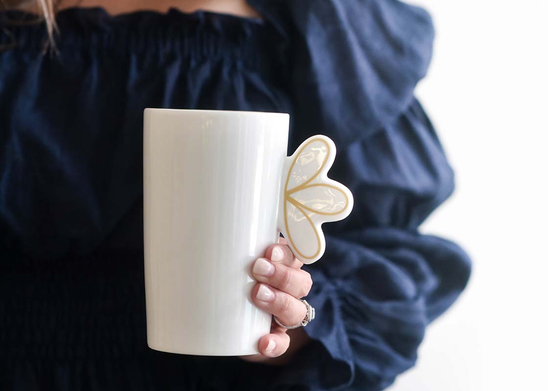 Close up of Woman Holding Deco Gold Scallop Mug in Front of Her