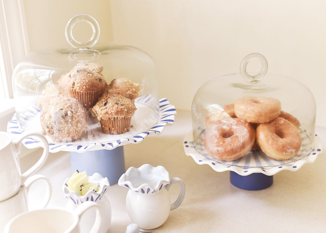 Cropped View of Two Iris Blue Cake Stands with Glass Domes Covering Stacks of Muffins and Donuts with Coordinating Serveware