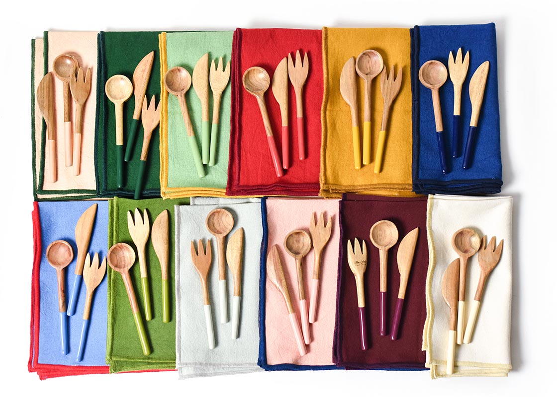 Overhead View of Coordinated Color Block Napkins and Wood Utensil Sets Including Brass Appetizer Spreader