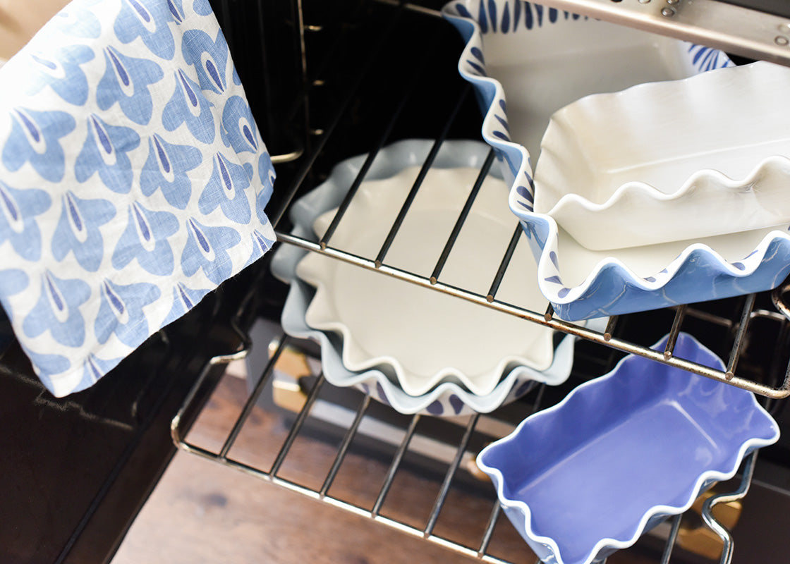 Cropped View of Stacks of Bakeware on Oven Racks with Coordinated Iris Blue Kitchen Towel
