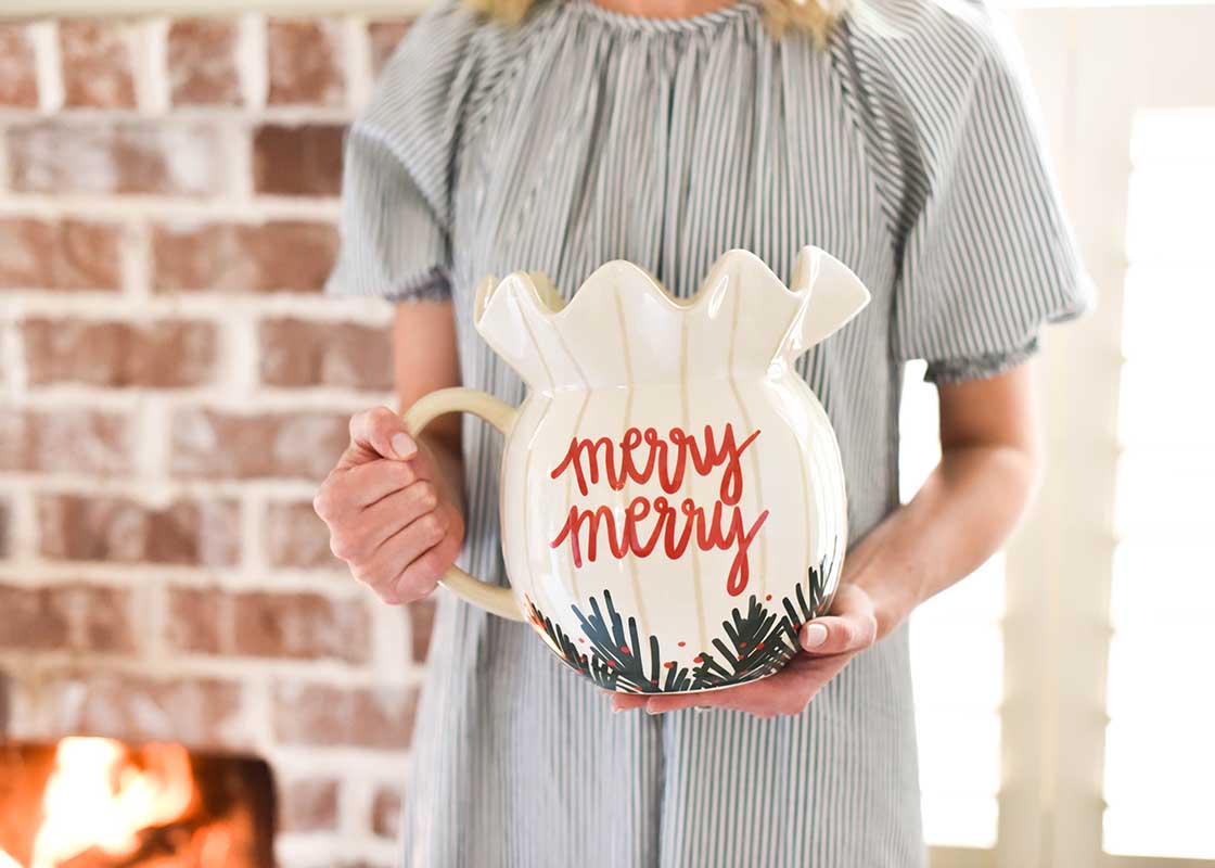 Front View of Woman Holding Balsam Stripes Ruffle Pitcher with "Merry Merry" Message Written in Brand Writing