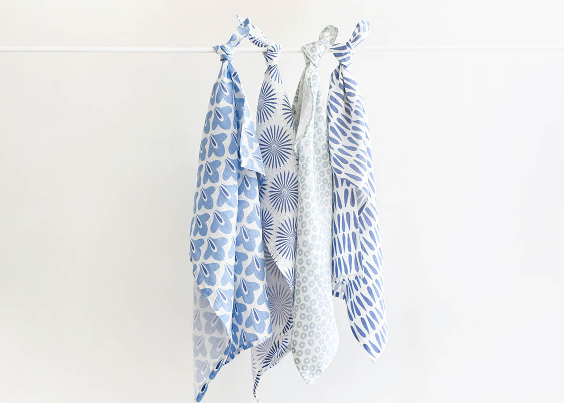 Front View of Kitchen Towels by Coton Colors Including Iris Blue Burst Design Tied on Rod