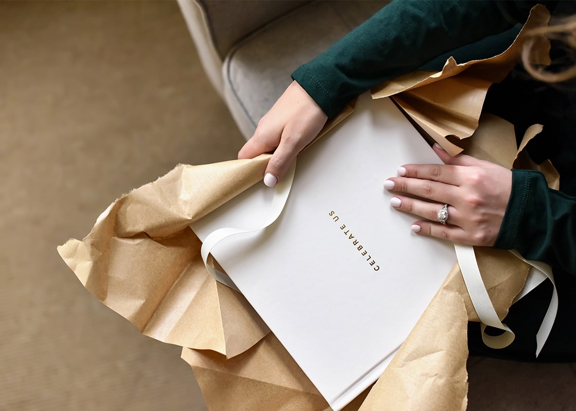 Overhead View of Bride Unwrapping a Gifted Celebrate Us Book