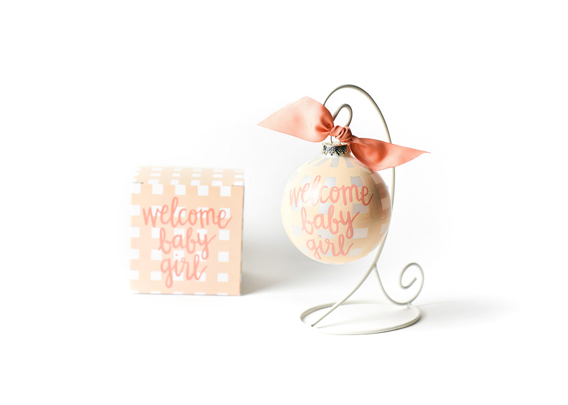 Front View of Welcome Baby Girl Gingham Glass Ornament Placed on White Display Stand with Matching Box