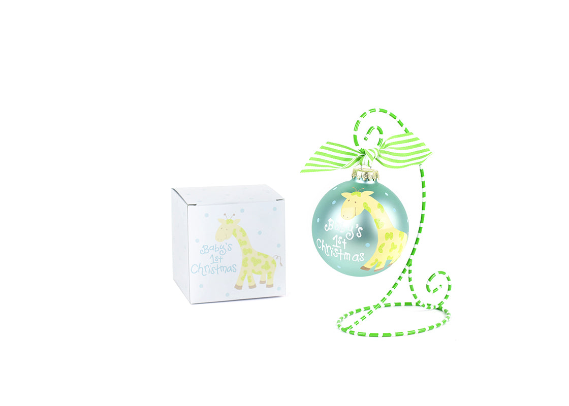 Front View of Blue Baby's First Christmas Giraffe Glass Ornament Placed on Green and White Stripe Display Stand with Matching Box