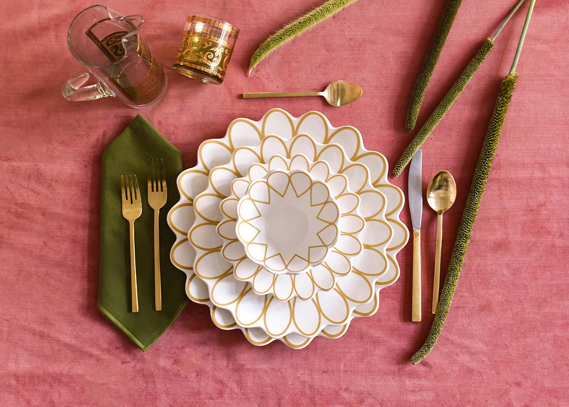 Overhead View of Coordinated Place Setting with Deco Gold Scallop Dinner Plate Set on Soft Pink Fabric