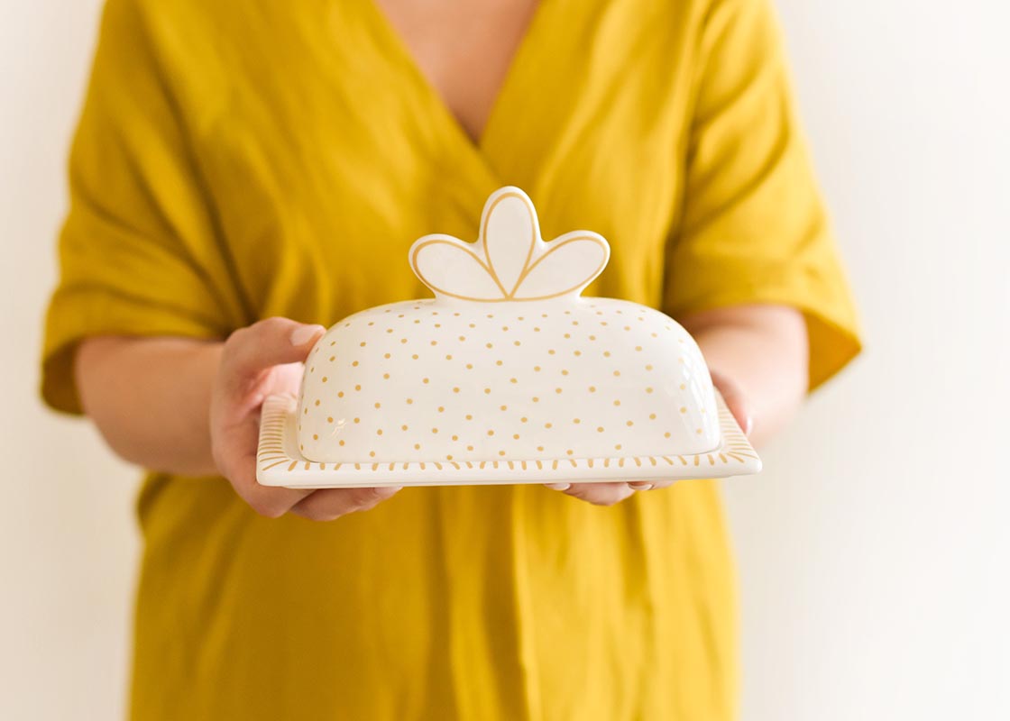 Front View of Woman Holding Deco Gold Scallop Knob Butter Dish