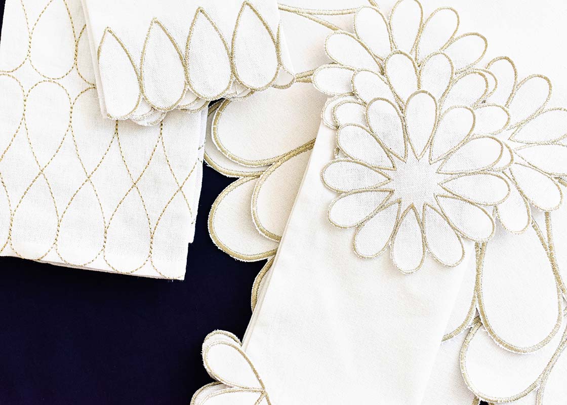 Overhead View of Stacks of Scalloped Edged Linens From Deco Collection Including Deco Gold Scallop Cocktail Napkins Set of 4