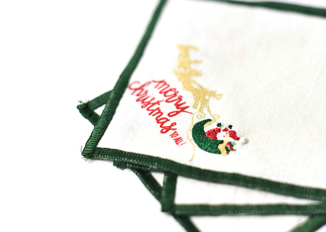 Cropped Close up of Embroidery on Loosely Stacked Flying Santa Cocktail Napkin Showcasing Beautiful Texture of Fabric