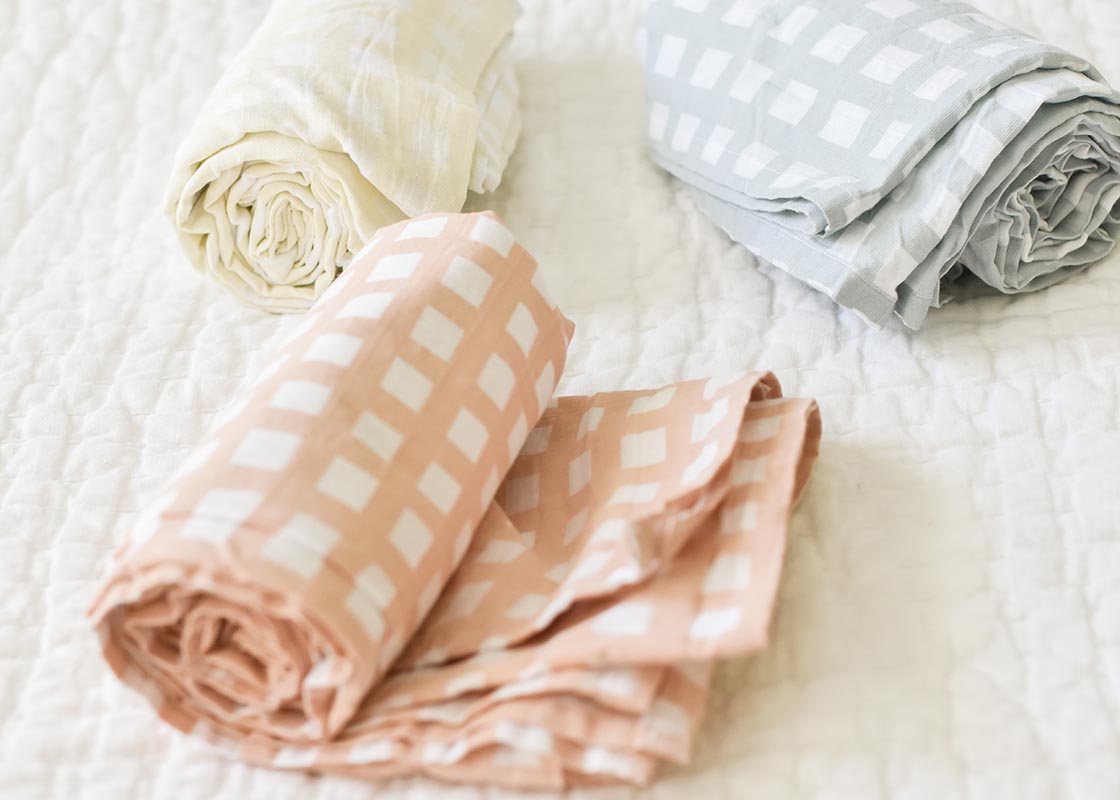 Front View of Rolled Pastel Swaddles Including Ecru Gingham Swaddle