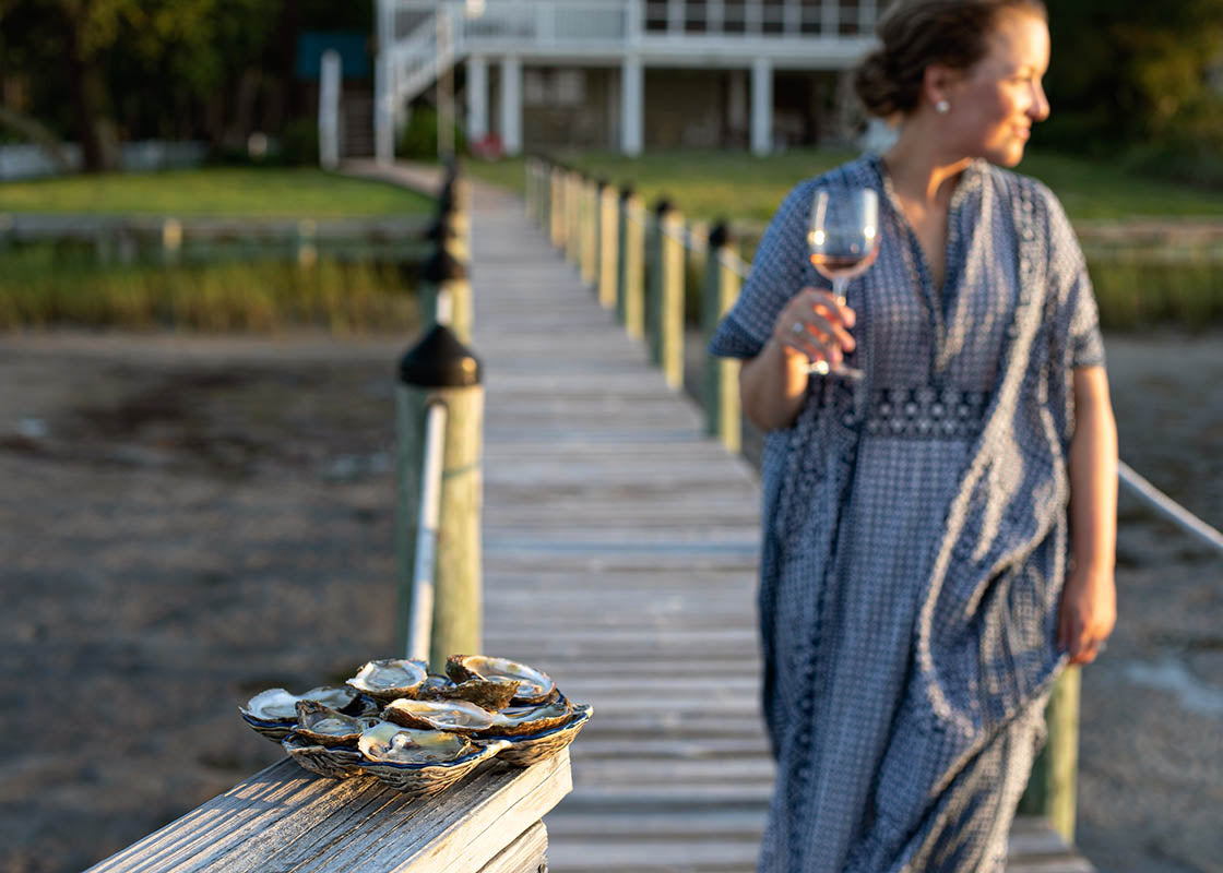 Front View of Woman Enjoying Evening with Wine and Oysters on Oyster Half Dozen Platter