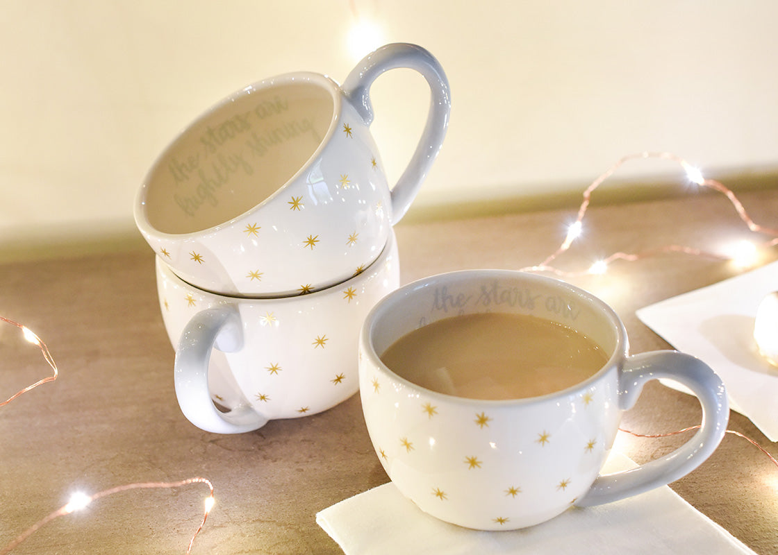 Front View of Interior and Exterior View of Nativity Scene Mugs with Sparkly Gold Stars and Script Writing Inside Rim