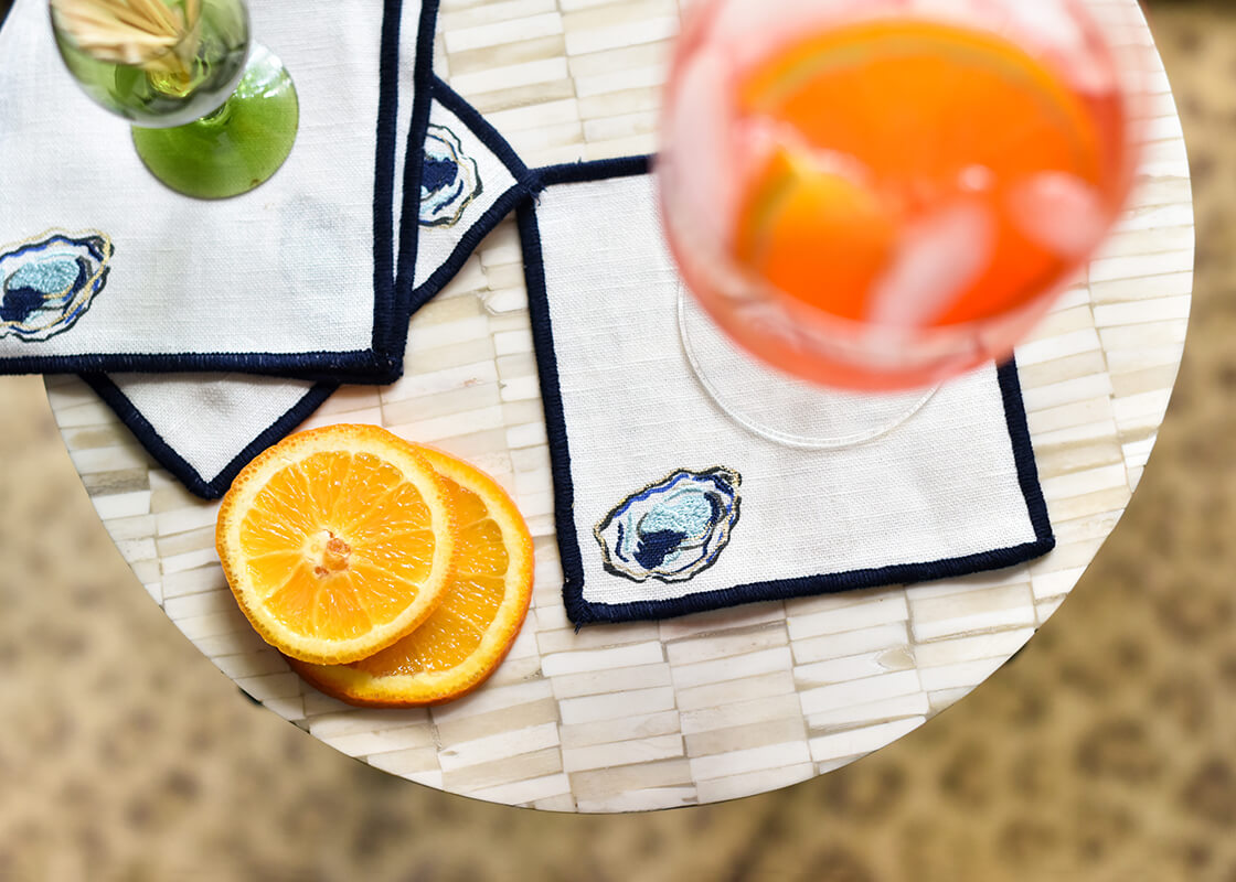 Overhead View of Embroidered Oyster Design on Linen Cocktail Napkin