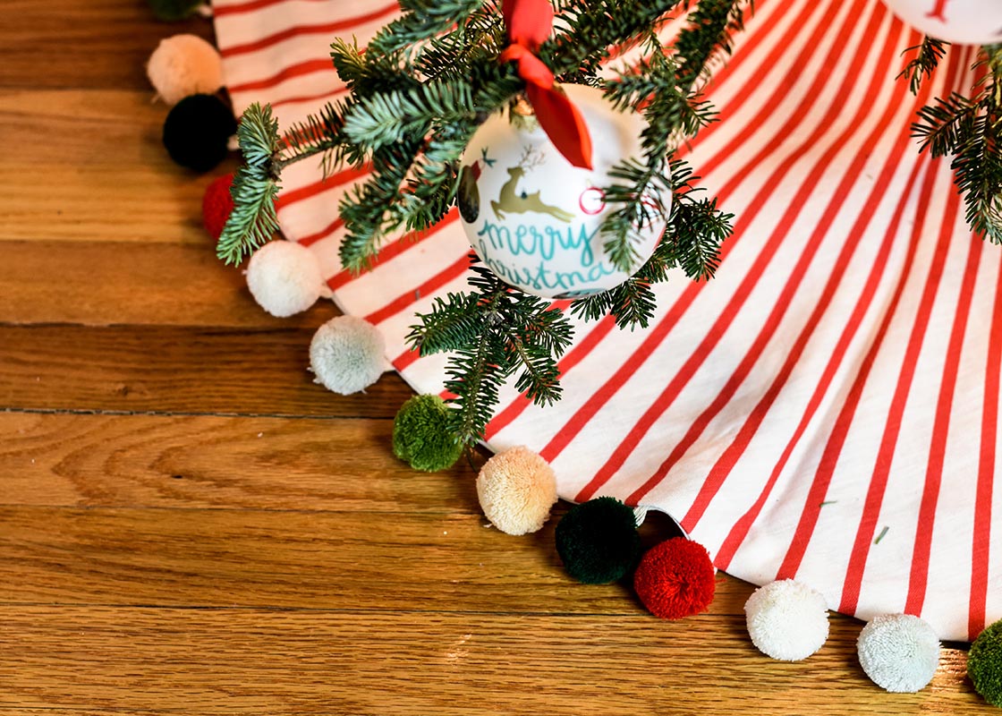 Overhead View of Red Stripe Tree Skirt with Pom Poms Under Christmas Tree