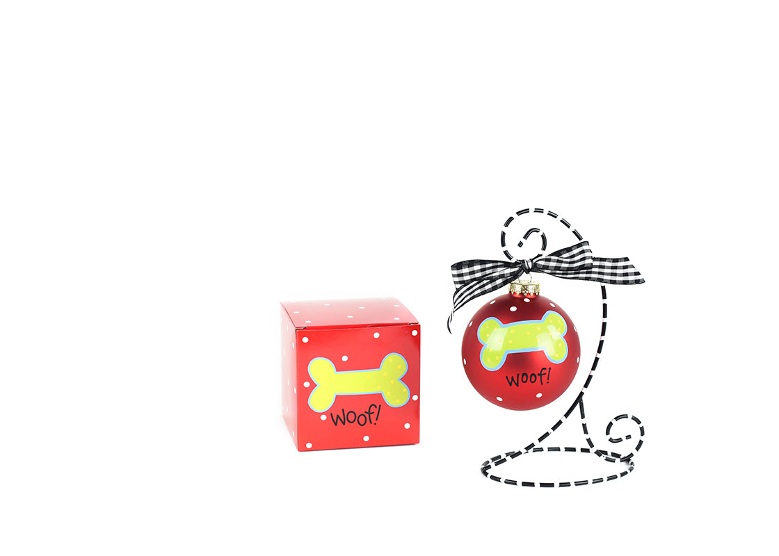 Front View of Red Woof Dog Bone Glass Ornament Placed on Black and White Stripe Display Stand with Matching Box