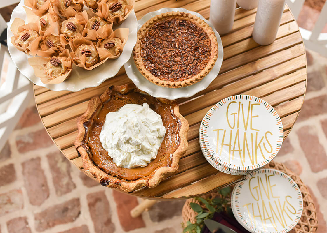 Overhead View of Thanksgiving Dessert Table with Signature White Small Cake Stand Serving Pecan Pie