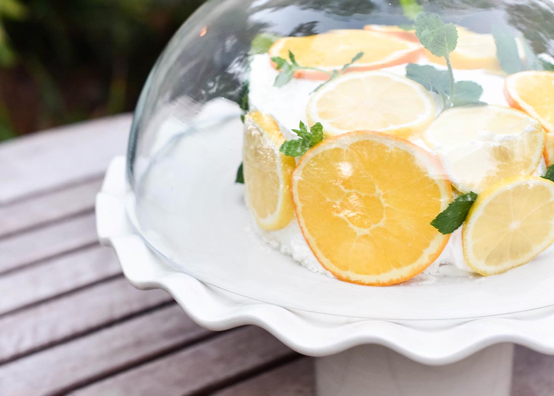 Extreme Cropped Close up of Glass Dome Covering Cake on Signature White Ruffle Cake Stand