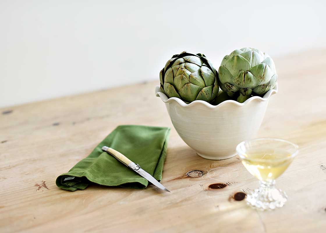 Front View of 9in Signature White Ruffle Bowl Filled with Fresh Artichokes