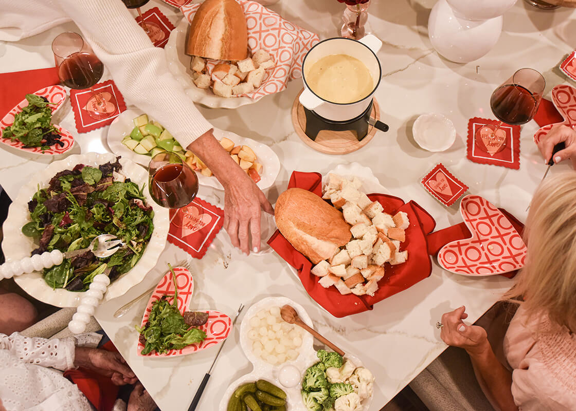 Overhead View of People Around aValentine Themed Dinner Table with Signature White Knob Serving Spoon placed for Serving