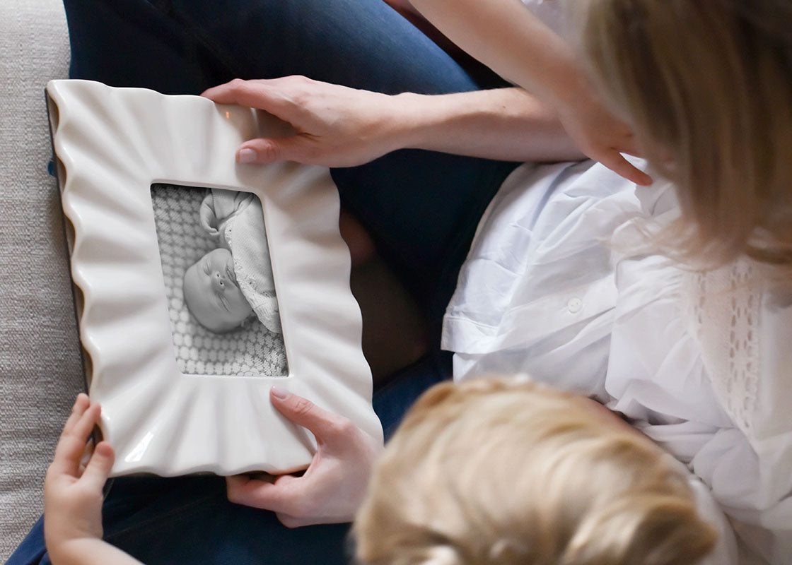 Overhead View of Woman sitting with a child holding a Signature White Ruffle Rectangle Frame