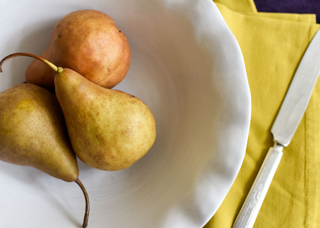 Overhead View of Best Bowl Signature White Ruffle Tableware Holding Pears